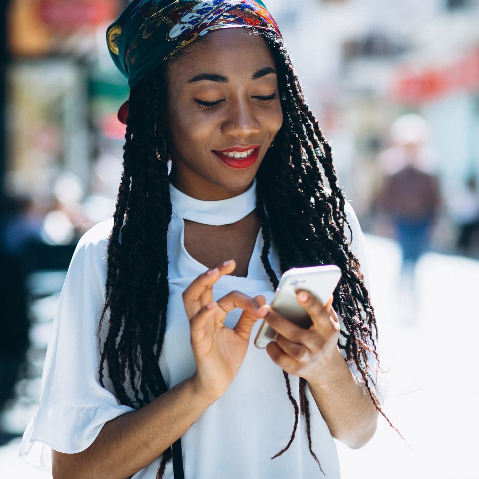 A traveller using the Omanga app on her phone on a city street.